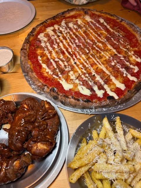 Pizza with garlic sauce drizzle, chicken tenders and parmesan fries